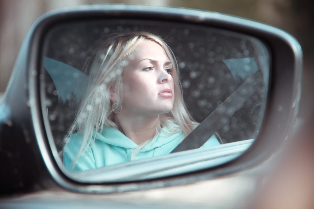 female college student in car mirror